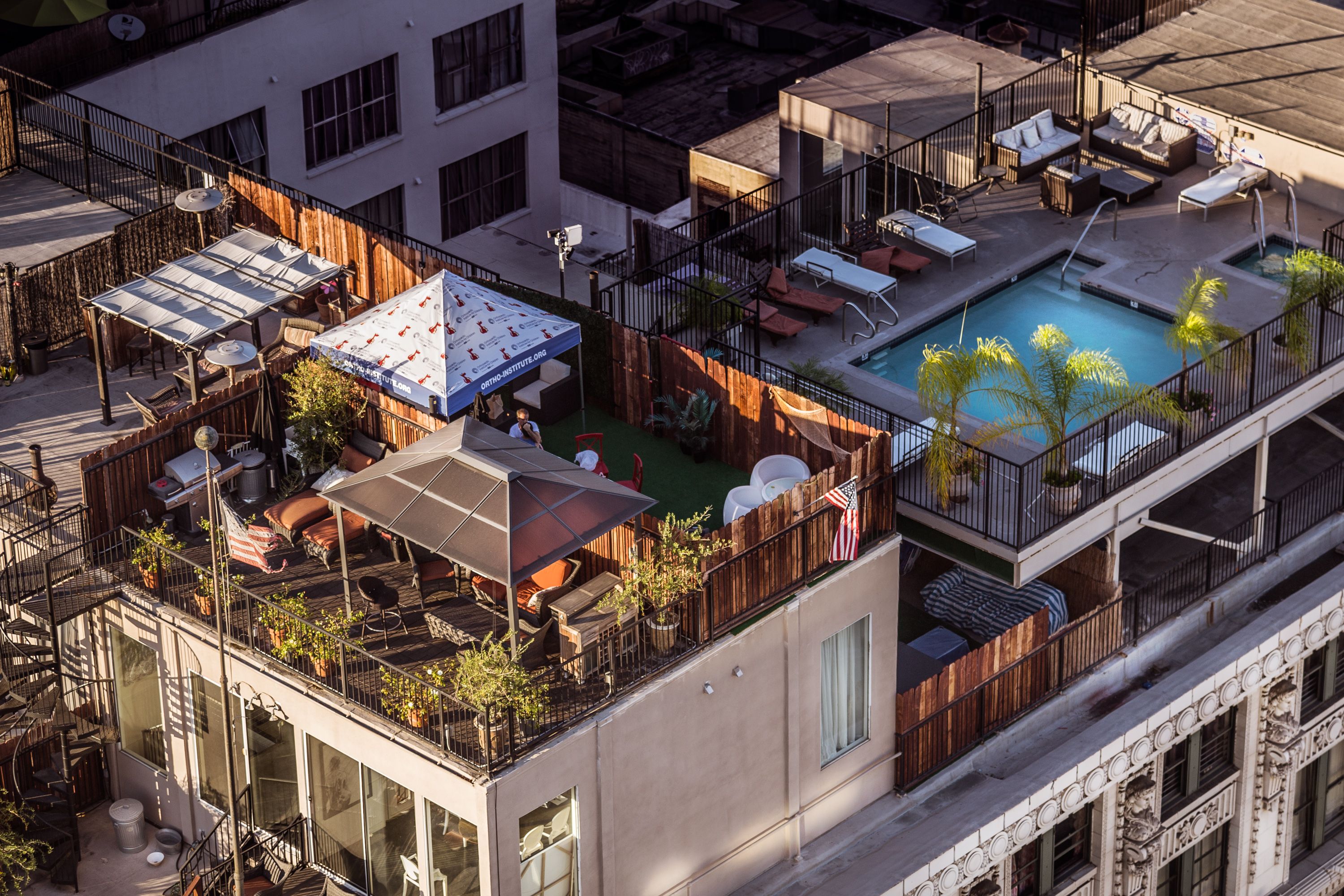Aerial view of a stylish rooftop terrace with a pool and seating area in a city setting